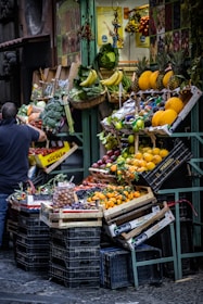 a person standing next to a fruit stand