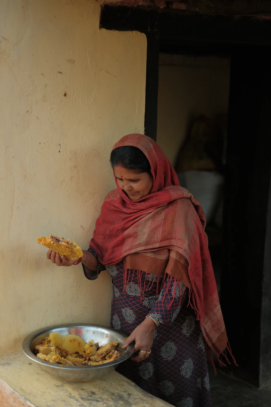 Woman in a red head scarf holding a plate of food