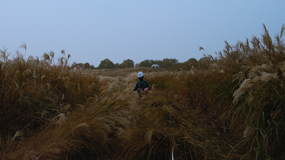 a person sitting in a field of tall grass