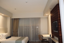 a hotel room with a tv and a bed