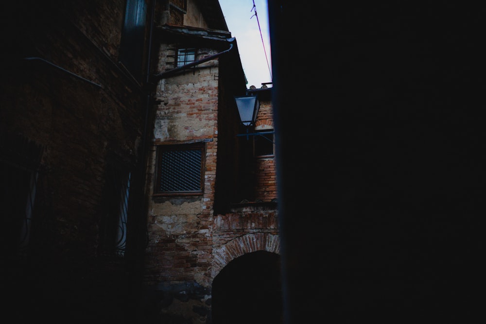 a brick building with a lamp on the side