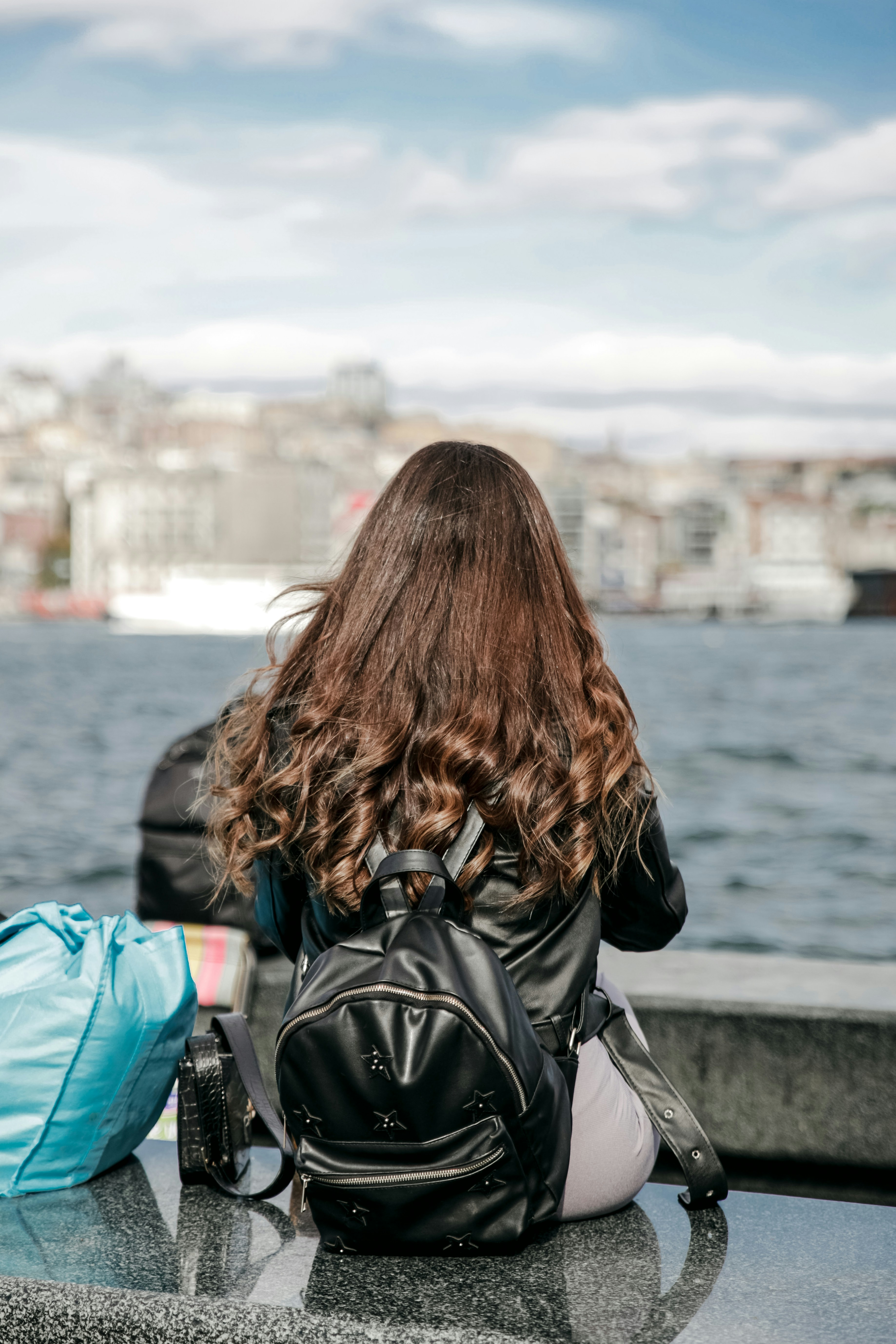 a person sitting on a bench looking out over the water