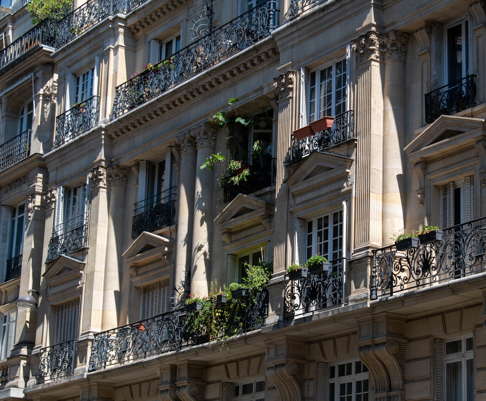 a building with balconies and plants on the windows