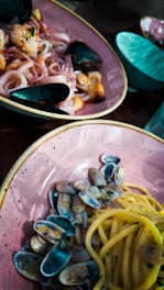 Elegant Sicilian seafood dish served on a rustic ceramic plate with chili pepper accents.