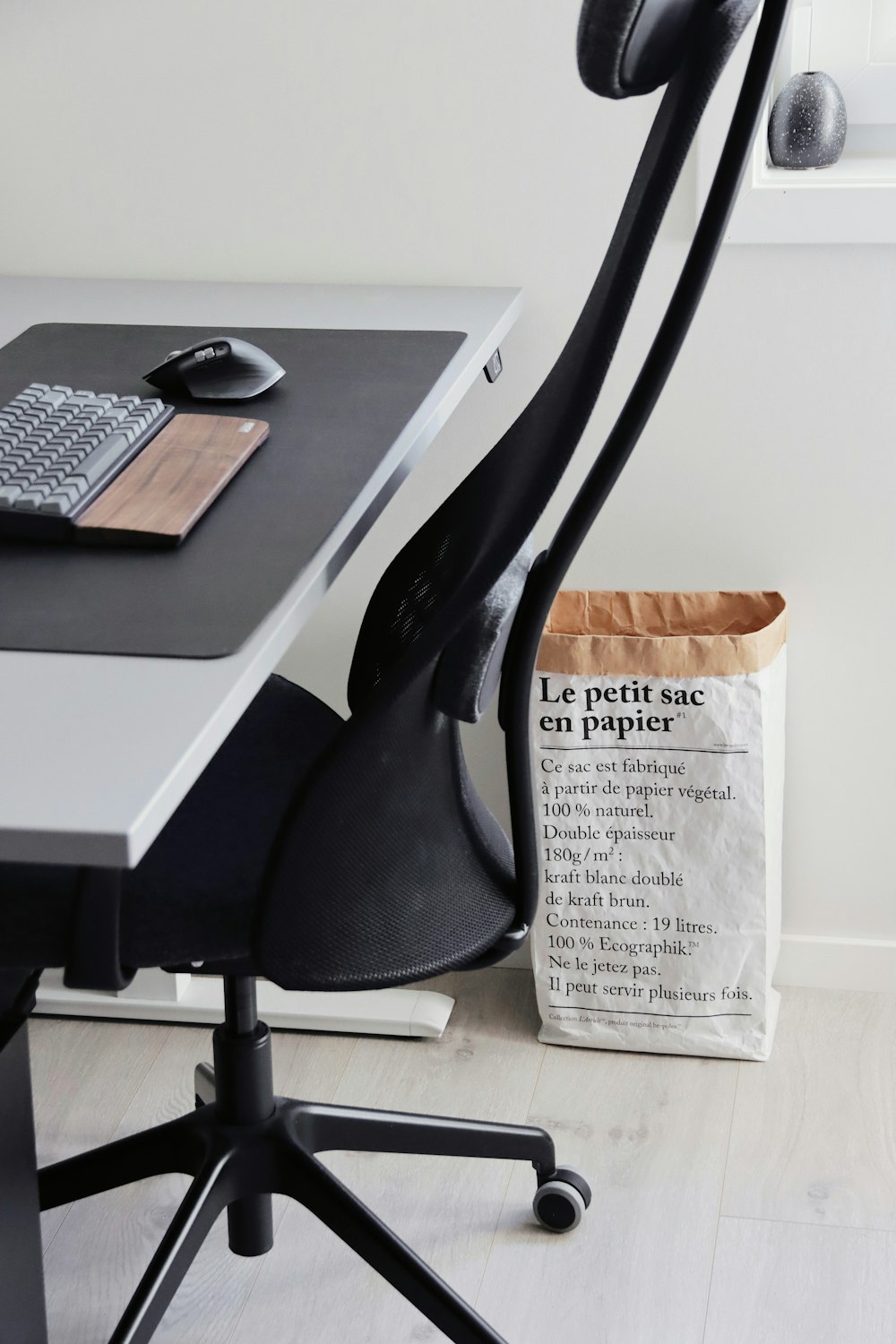 una scrivania nera con un sacchetto di carta su di esso