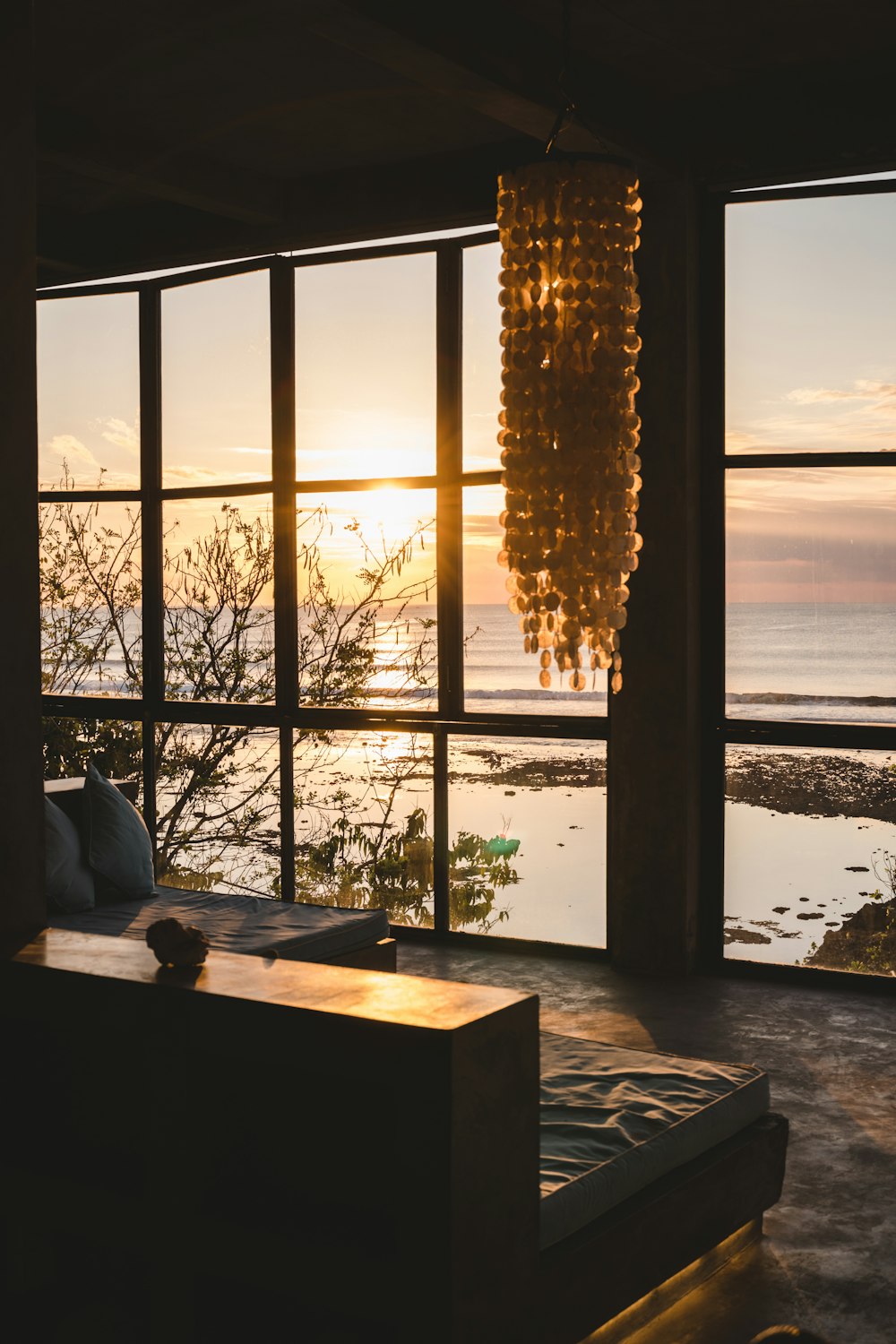 a window with a view of the ocean and a sunset