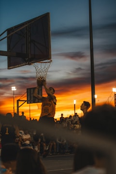 A vibrant photo of a basketball player mid-jump shot during a game.