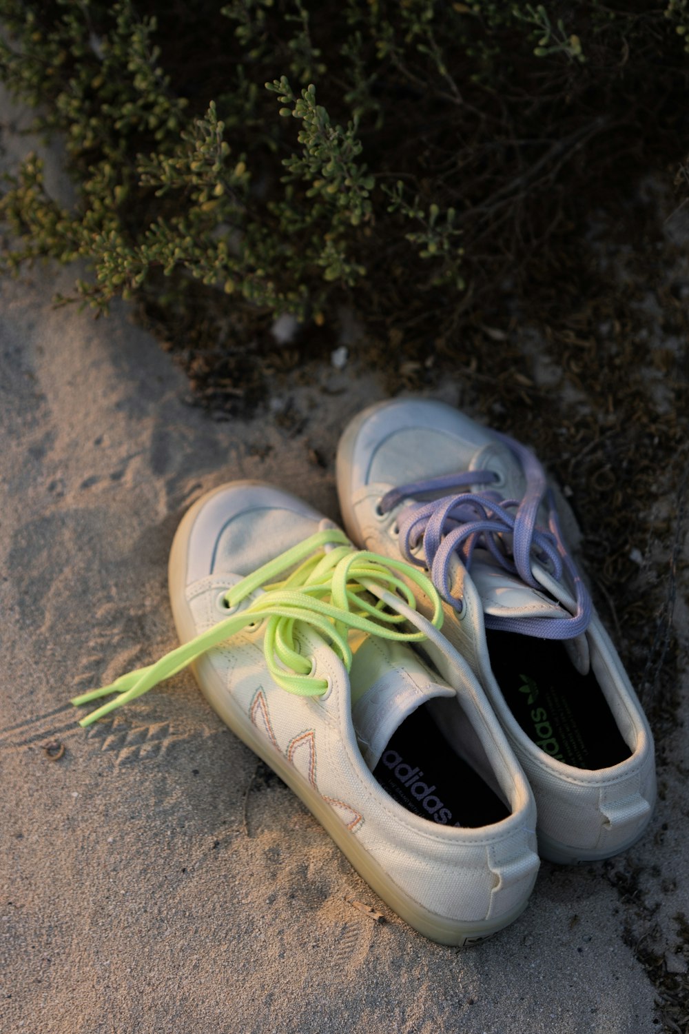 a pair of shoes with a green string tied around them