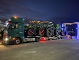 Experienced team loading machinery onto a truck at dusk.