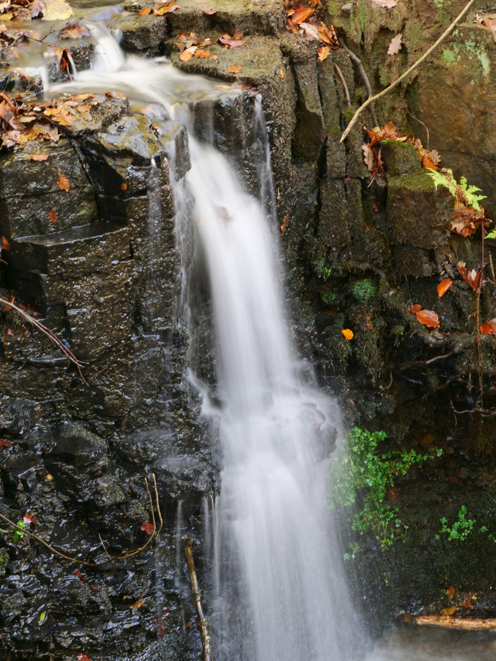 a waterfall with rocks and moss
