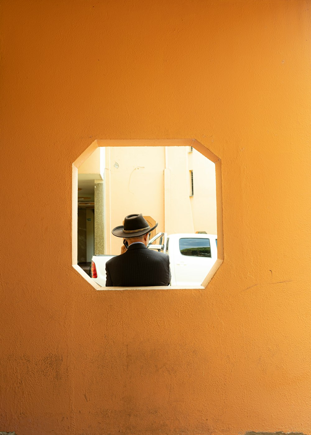 a person in a hat looking out a window