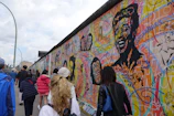 A lively group of families and kids painting colorful murals outdoors.
