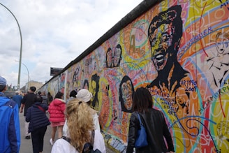 A group of artists traveling together, exploring a vibrant city street filled with murals.