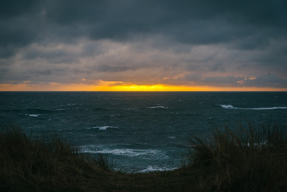 a beach with waves and a sunset