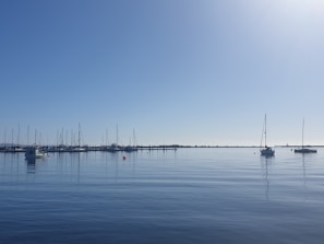 Sailboats gently floating in the marina of Porto Cervo under a clear blue sky