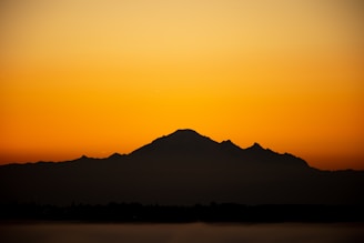 A mountain range silhouette at dawn, symbolizing strength and steady growth.