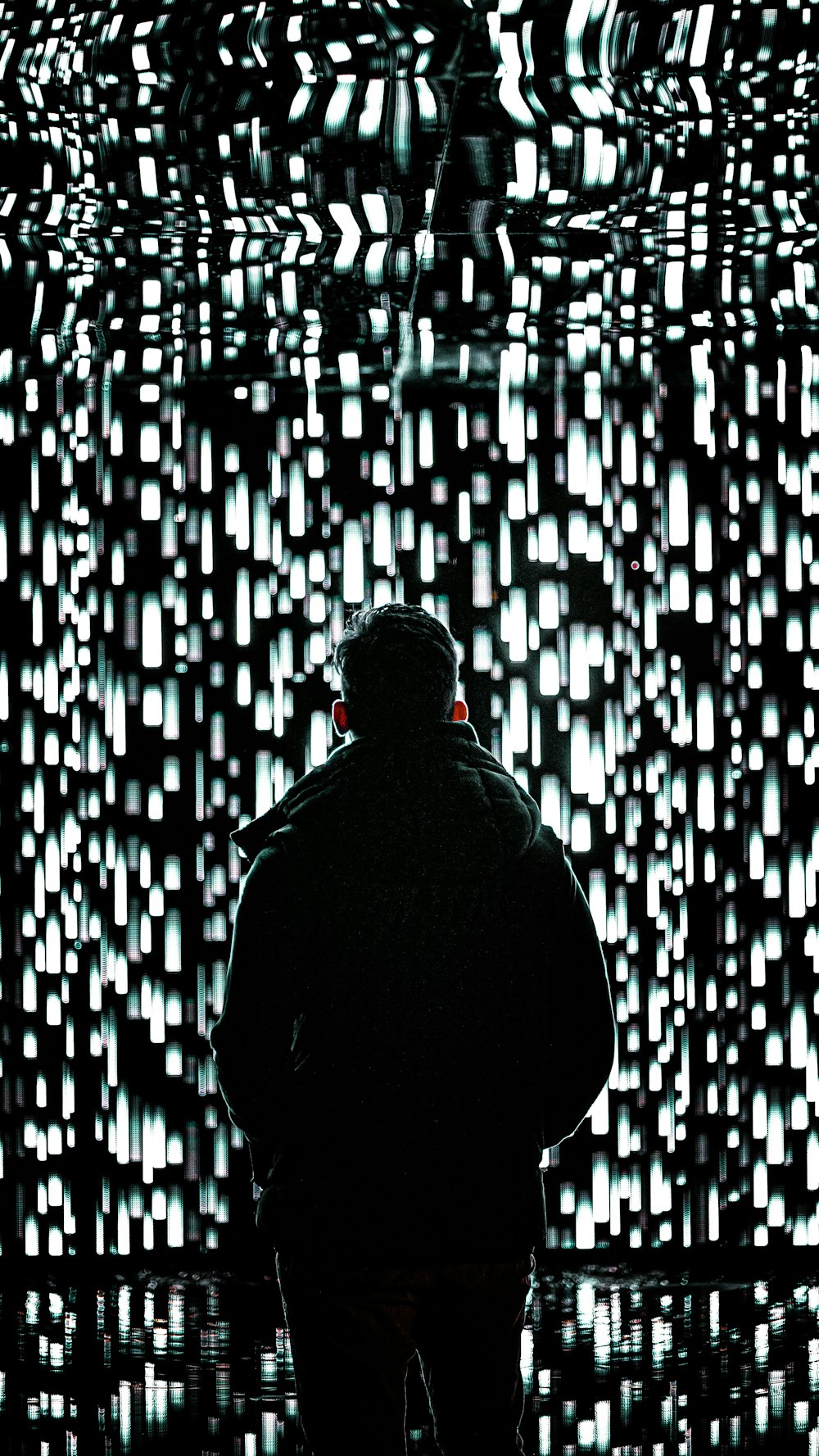 a person standing in front of a wall of lights