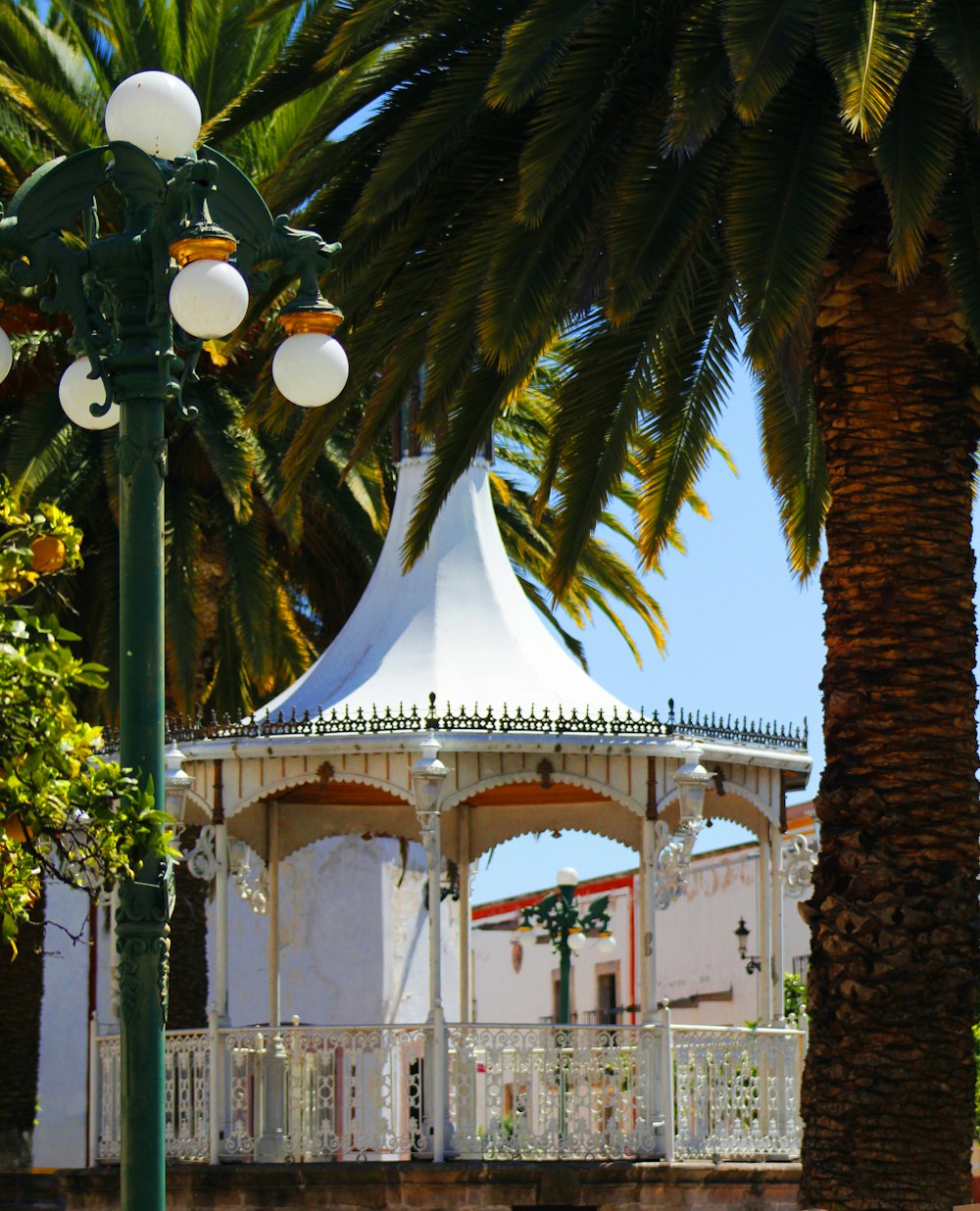 a white gazebo with a white roof and a white fence