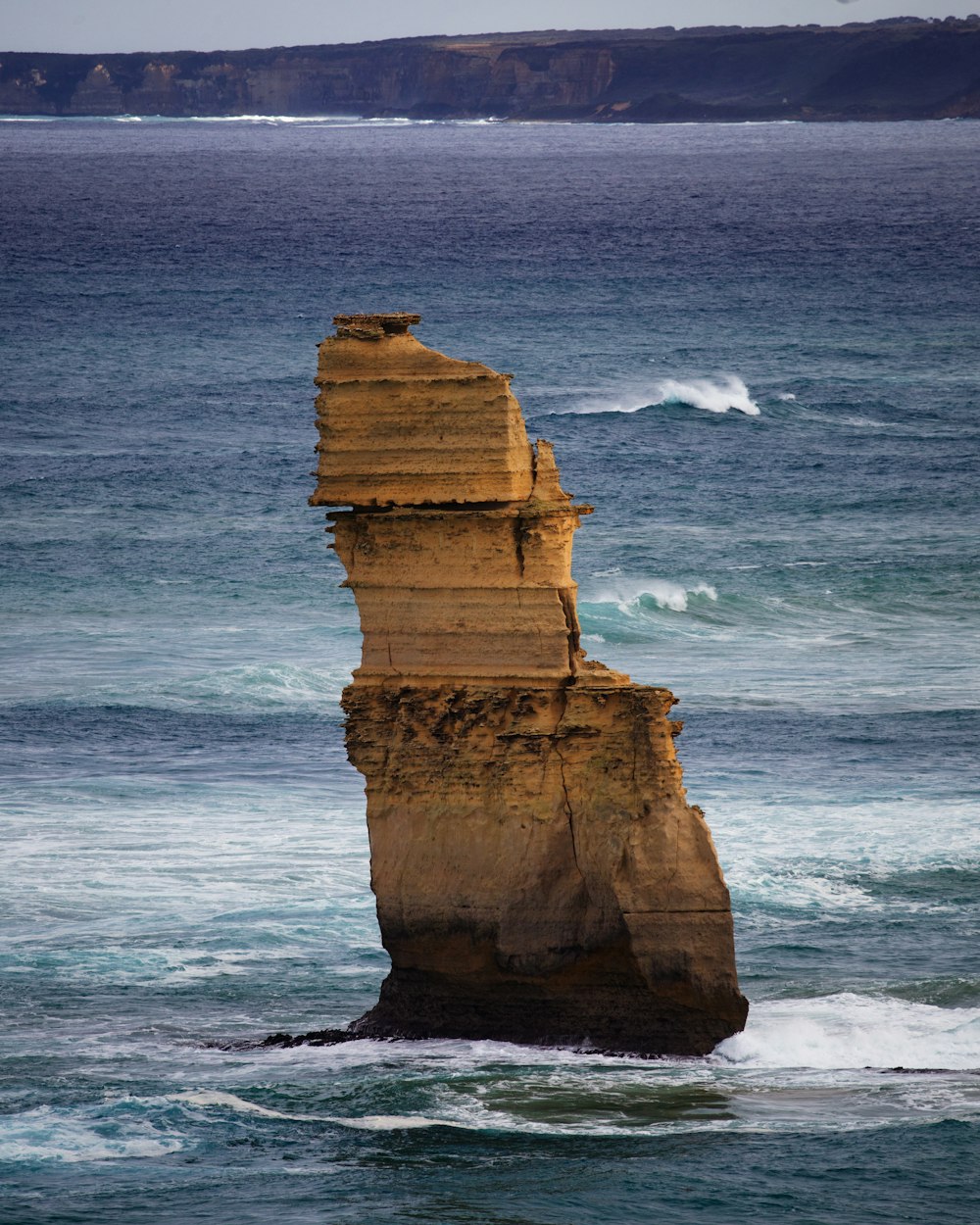 a large rock in the middle of the ocean