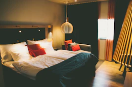 A cozy Deluxe Room with warm lighting, a comfortable bed, and tasteful decor.