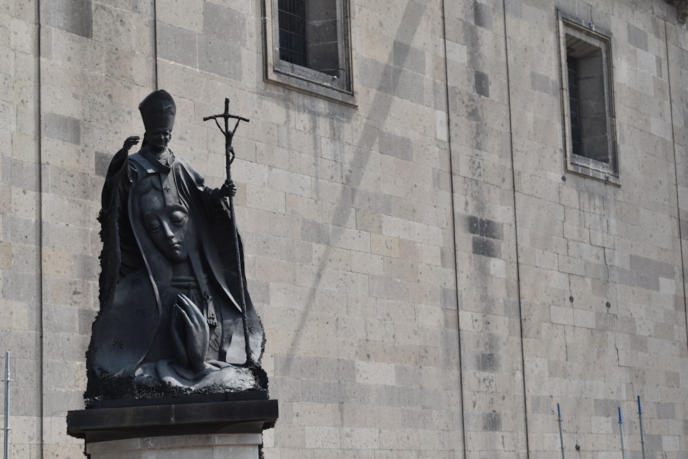 a statue of a person holding a cross and a cross