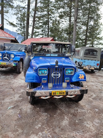 a blue truck parked in a dirt lot