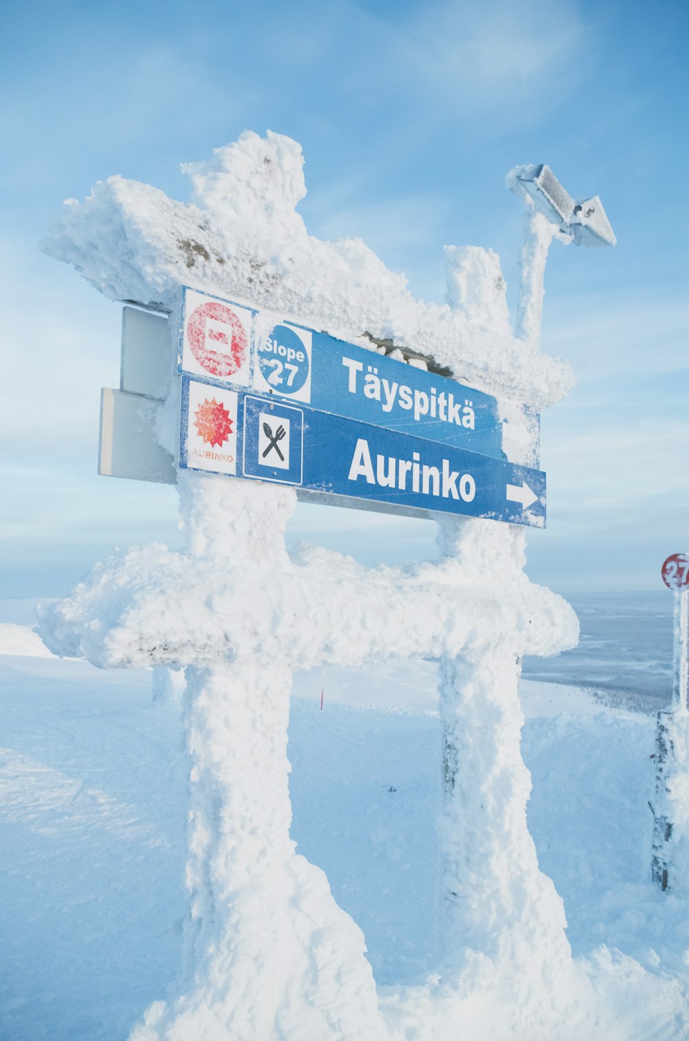 a street sign on a snow covered post