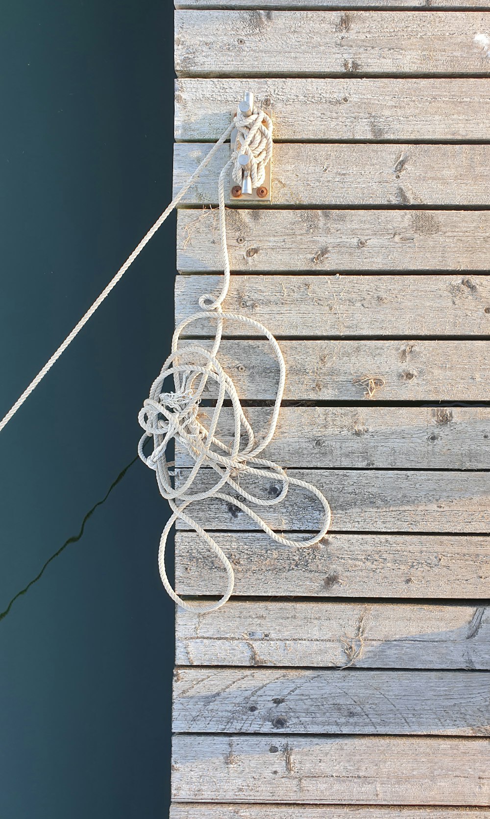 a white string tied to a wooden wall
