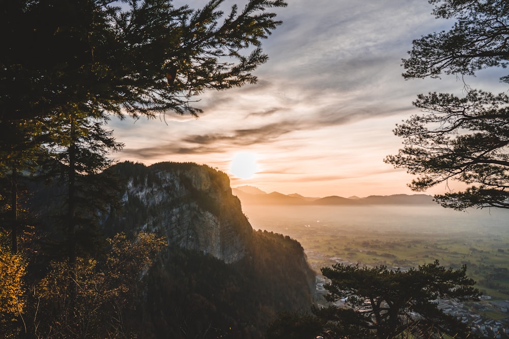 a view of a mountain and the sun