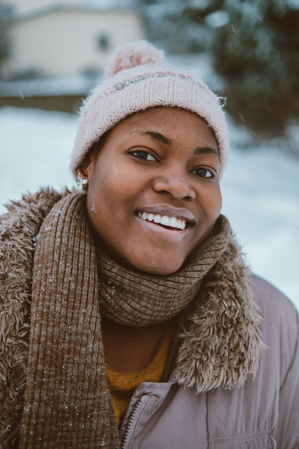 uma mulher usando um chapéu e sorrindo para a câmera