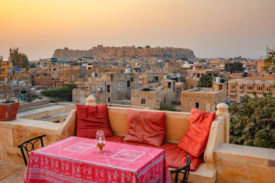a table and chairs on a balcony overlooking a city