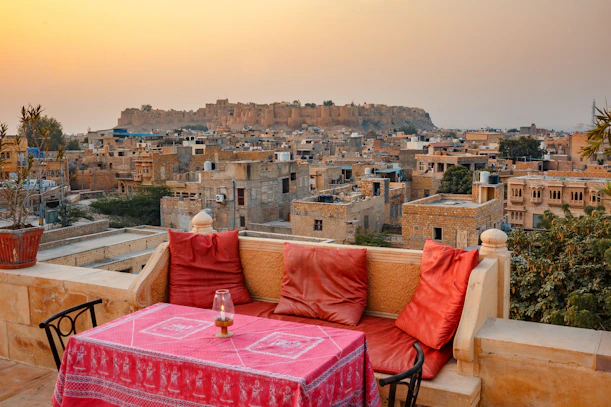 a table and chairs on a balcony overlooking a city