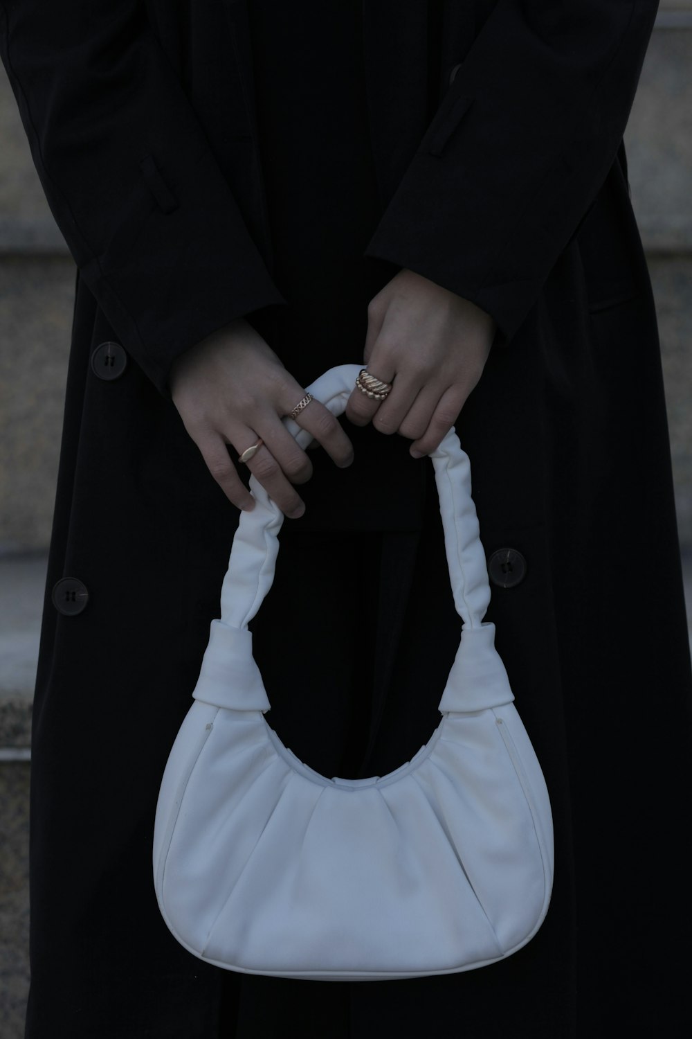 a person holding a white purse