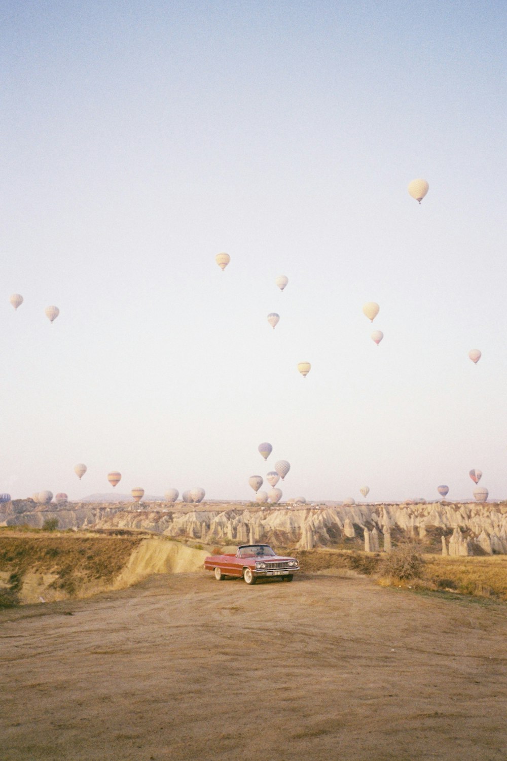 um carro dirigindo através de um campo de balões de ar quente