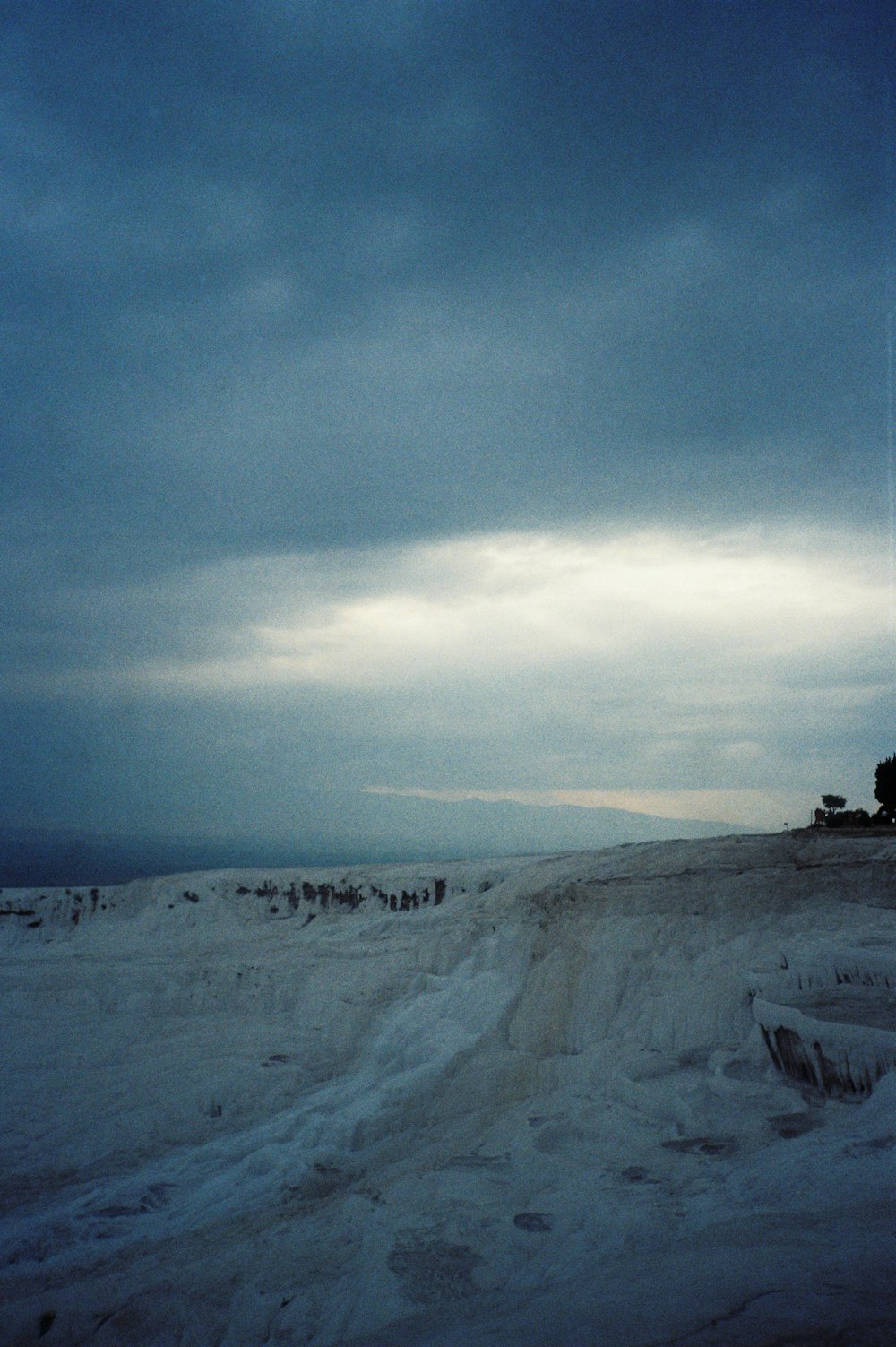 a snowy landscape with a cloudy sky