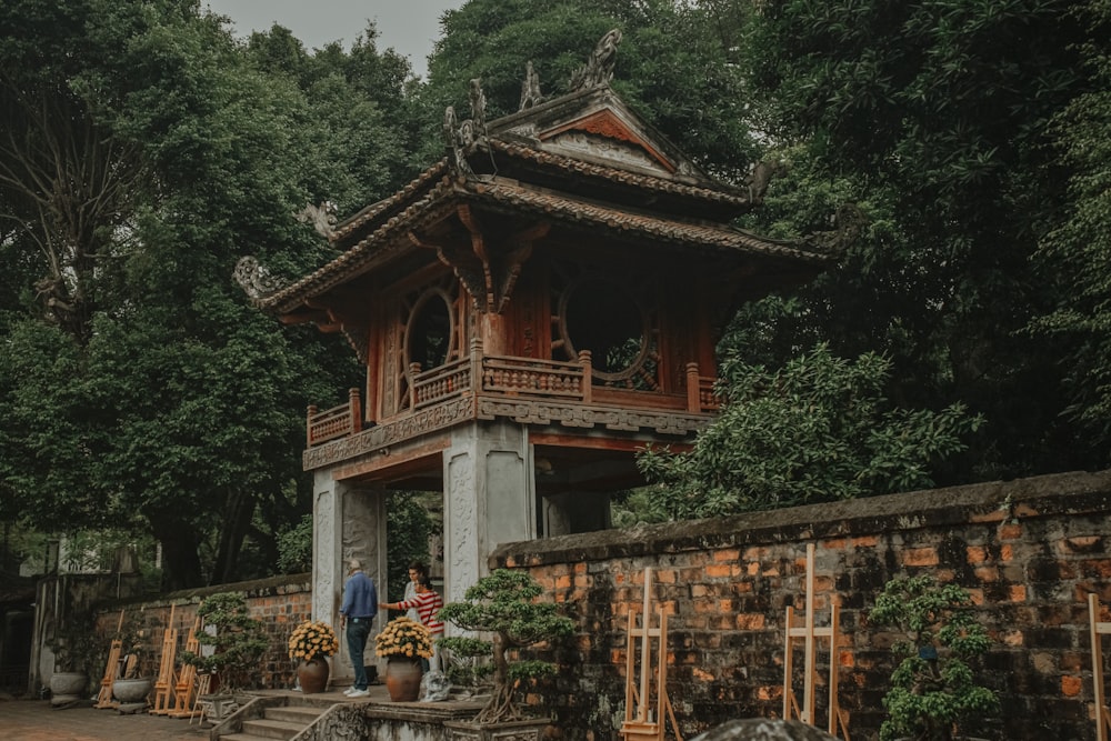 une pagode avec quelques personnes debout devant elle