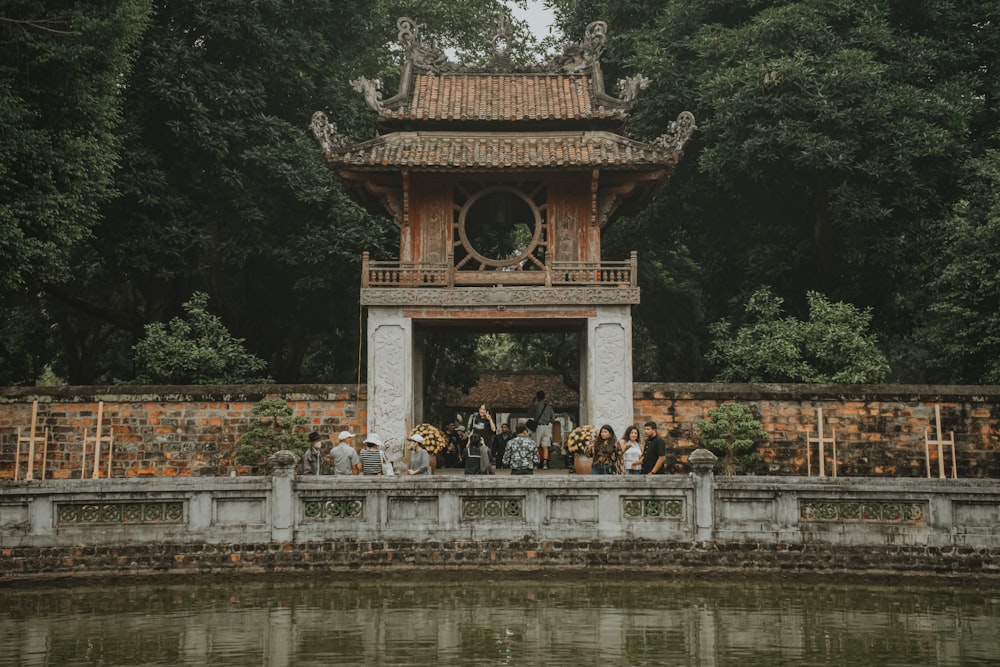 a group of people standing on a bridge over water