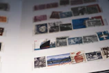 Close-up of hands sorting vintage stamps into thematic collections.