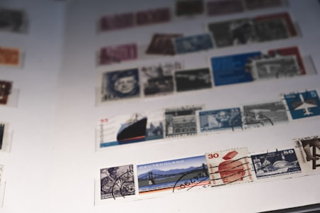 A collection of postage stamps arranged in rows on album pages, showcasing various designs and colors. The stamps feature different illustrations, including portraits, architectural landmarks, and symbolic imagery. They appear to be organized neatly, creating a visually engaging pattern.
