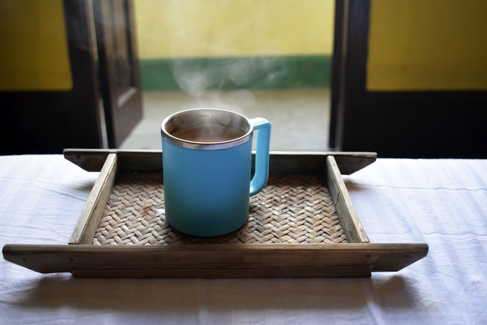 une tasse bleue sur une surface en bois