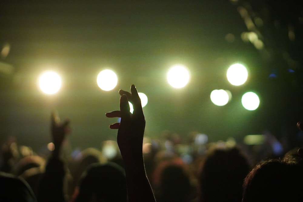 a crowd of people with their hands up in the air