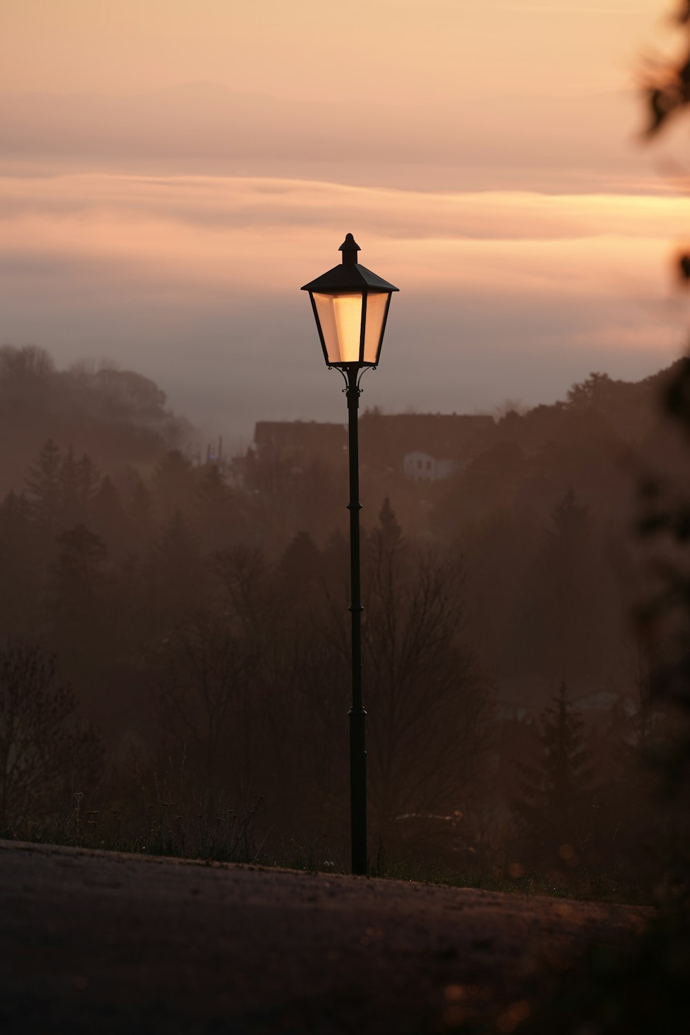 a lamp post with a sunset in the background