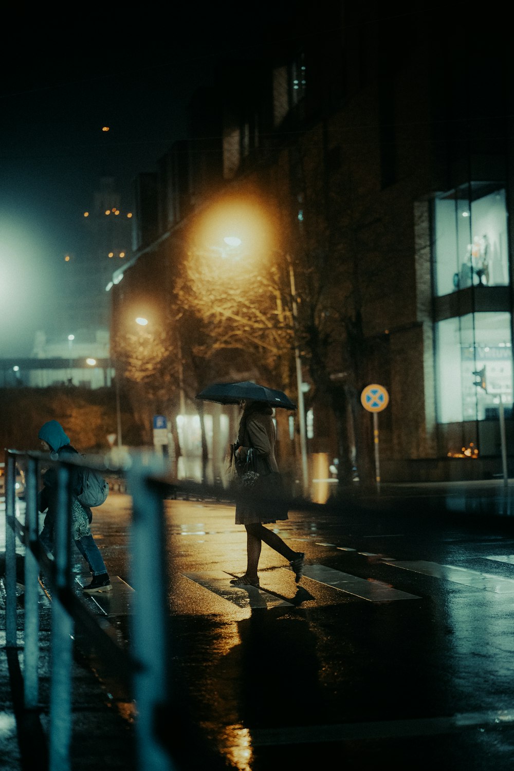 a person walks down a sidewalk with an umbrella