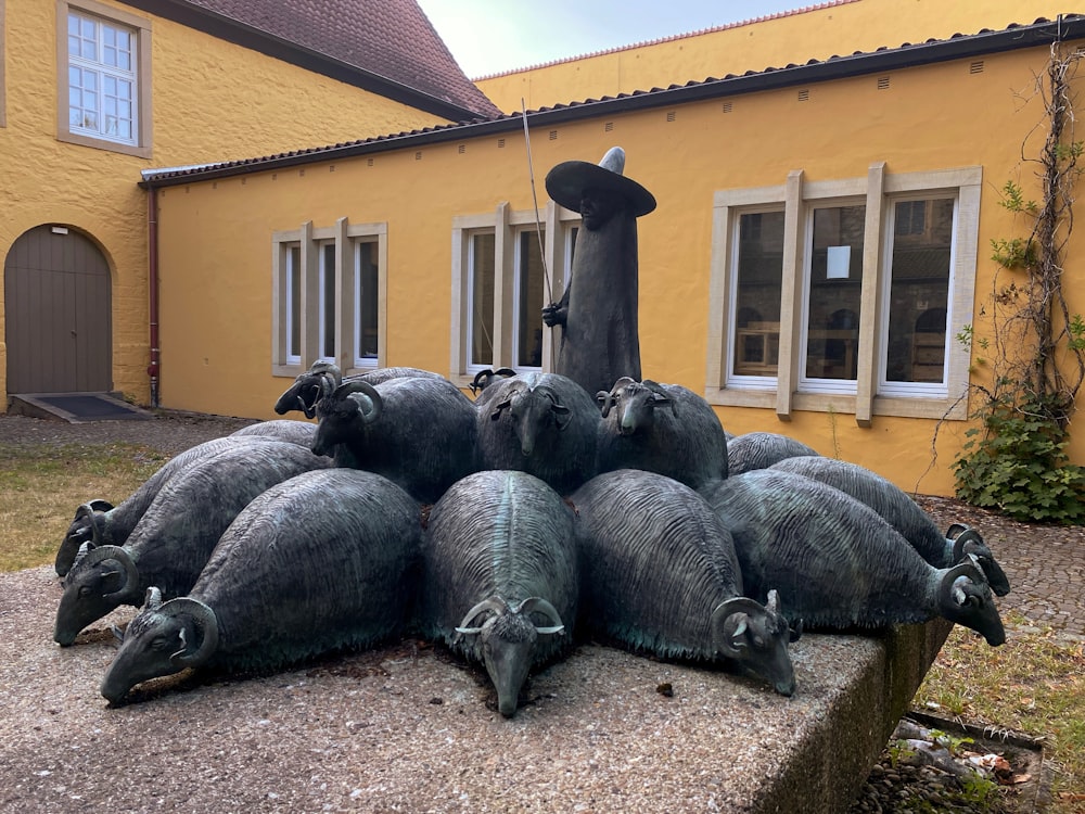 a group of gorillas lying on the ground outside a house