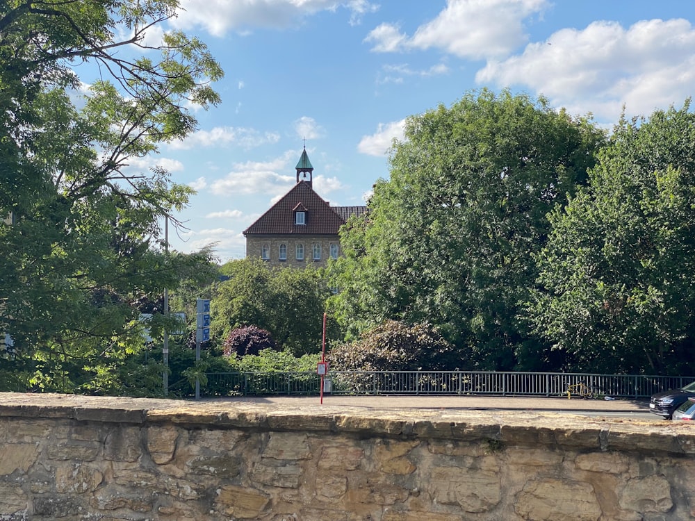 a stone wall with a building in the background