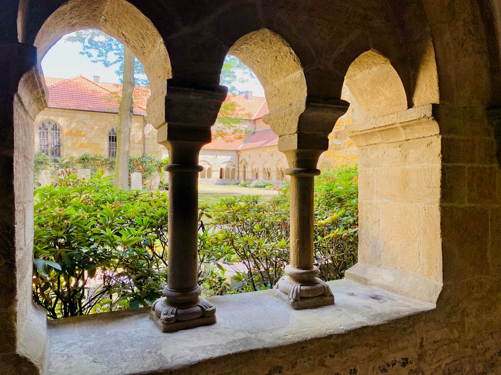 a stone archway with plants and a fountain