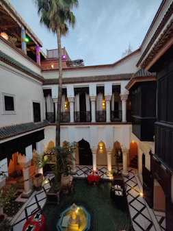 a courtyard with buildings and a palm tree