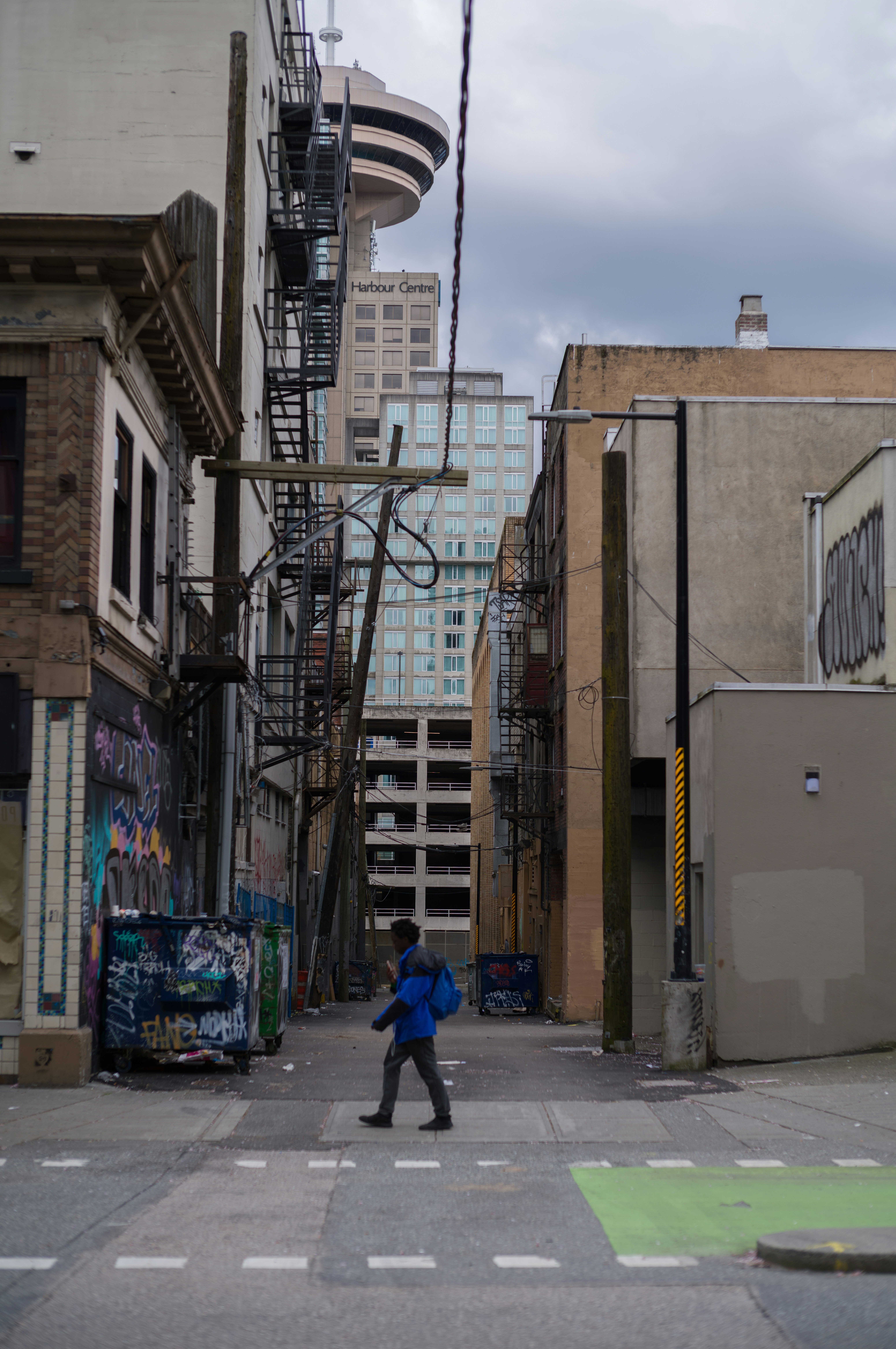a person walking on a street between buildings