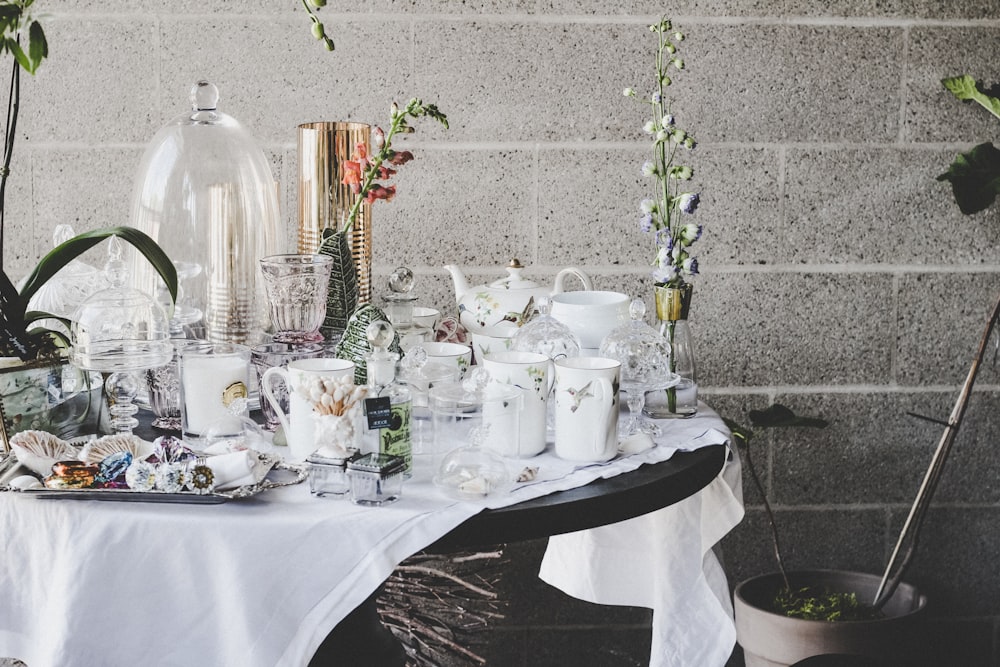 a table with white cups and saucers