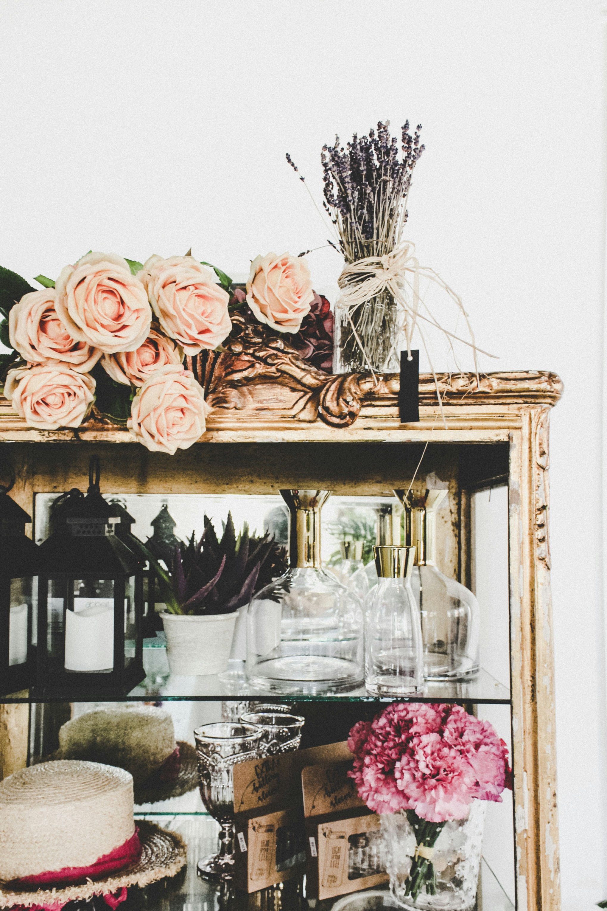 une étagère avec un vase de fleurs et des verres dessus